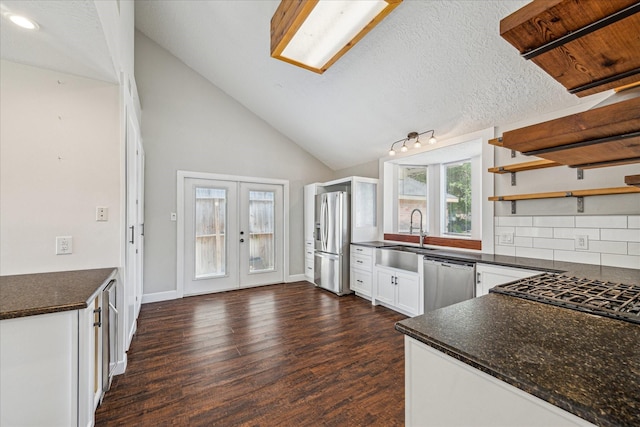 kitchen featuring open shelves, dark countertops, a sink, french doors, and stainless steel appliances