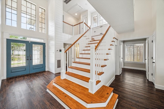 foyer entrance featuring a healthy amount of sunlight, french doors, stairs, and wood finished floors