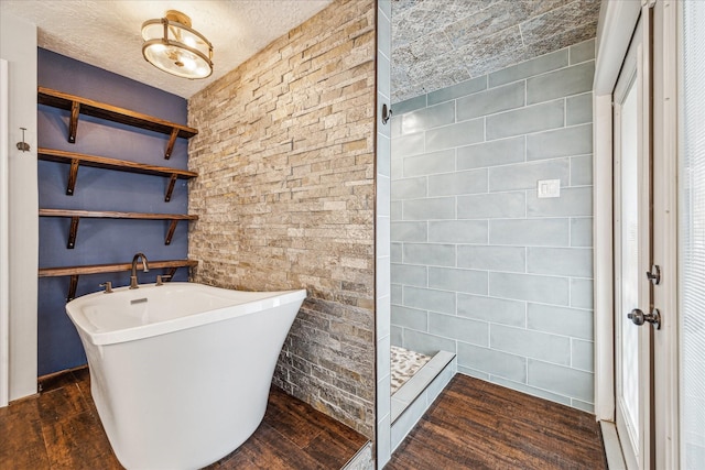 full bath with a freestanding bath, walk in shower, and wood finished floors
