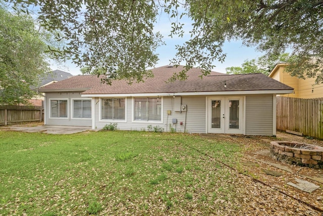 back of house with a fire pit, a patio, a fenced backyard, french doors, and a yard