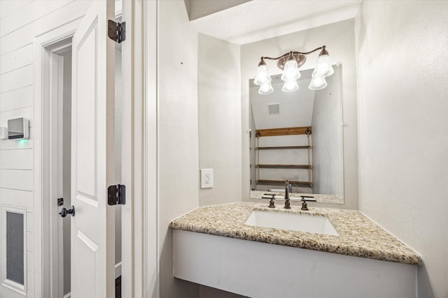 bathroom with an inviting chandelier, vanity, and visible vents