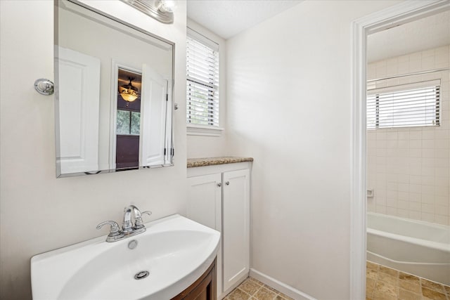 full bath featuring vanity and baseboards