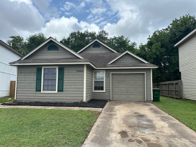 view of front of property with fence, an attached garage, driveway, and a front yard