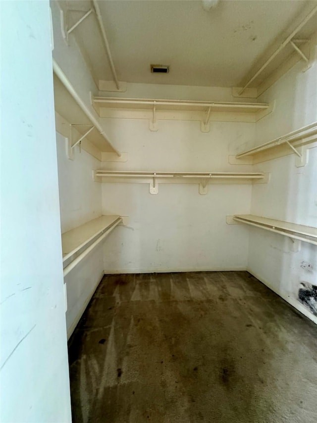 spacious closet with dark carpet