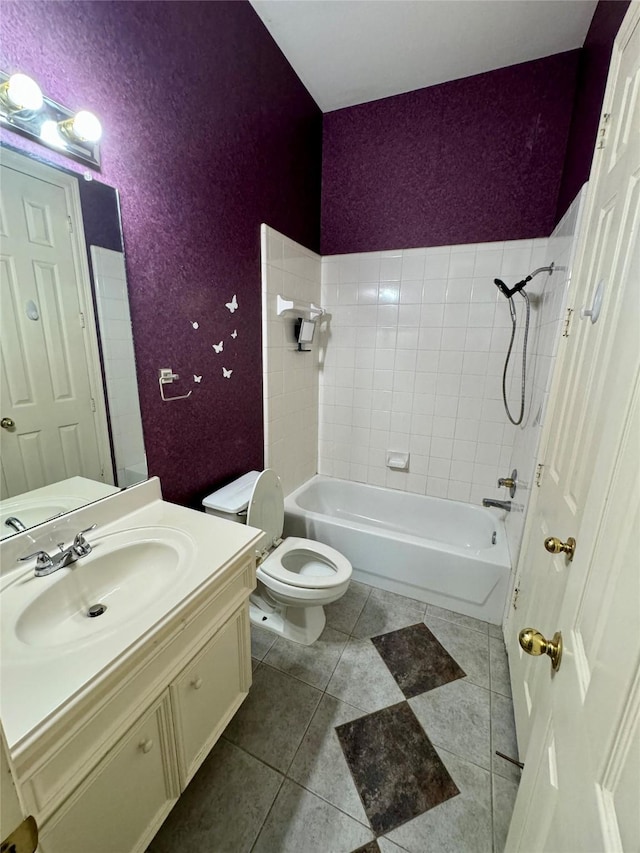bathroom with vanity, a textured wall, bathing tub / shower combination, toilet, and tile patterned floors