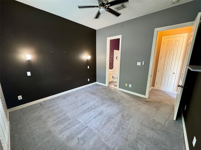 unfurnished bedroom featuring carpet floors, visible vents, baseboards, ceiling fan, and connected bathroom