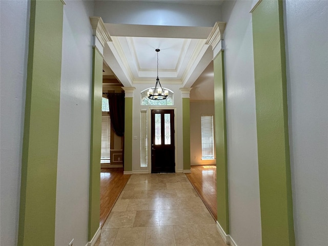 entrance foyer featuring crown molding, baseboards, a chandelier, and a healthy amount of sunlight