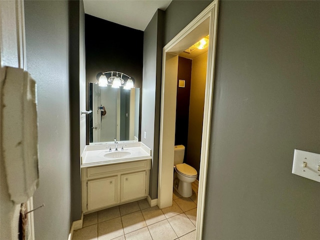 bathroom featuring tile patterned floors, baseboards, vanity, and toilet