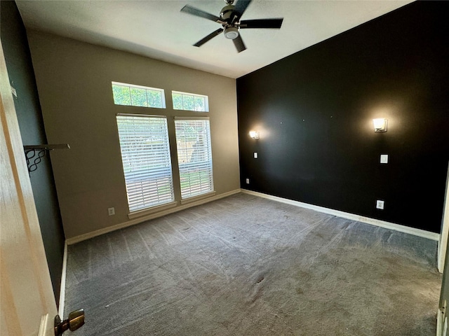 carpeted empty room with a ceiling fan and baseboards