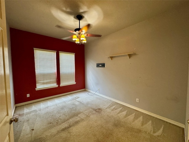 carpeted empty room with baseboards and a ceiling fan
