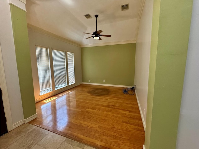 spare room featuring crown molding, ceiling fan, visible vents, and baseboards