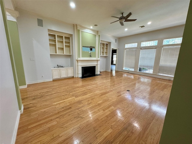 unfurnished living room featuring light wood-style floors, a ceiling fan, a fireplace with flush hearth, and baseboards