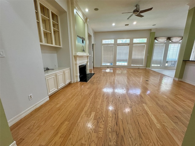 unfurnished living room with ceiling fan, light wood-style floors, a fireplace, recessed lighting, and baseboards