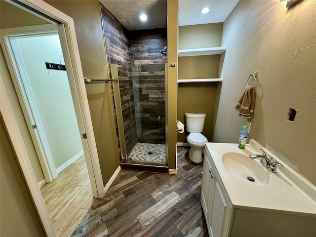 full bathroom featuring vanity, toilet, wood finished floors, and a stall shower
