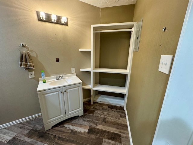 bathroom with vanity, baseboards, and wood finished floors