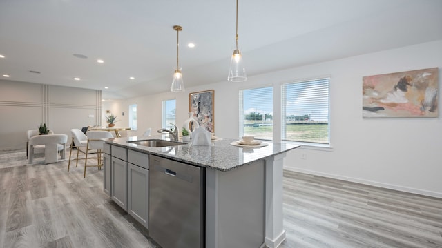 kitchen featuring a sink, gray cabinets, stainless steel dishwasher, and light wood-type flooring