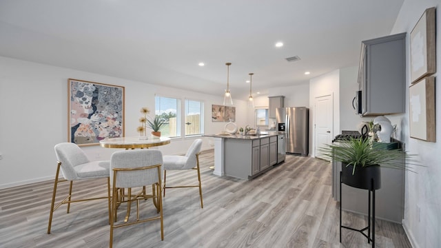 dining space featuring light wood-type flooring, recessed lighting, baseboards, and visible vents