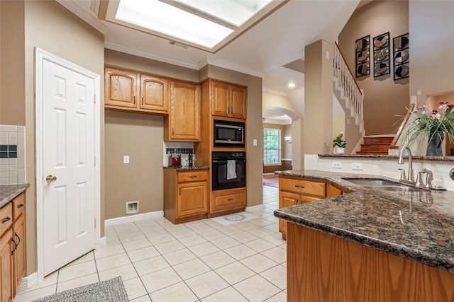 4103 Oak Blossom Ct, Houston, TX 77059 - kitchen with a sink, black oven, arched walkways, dark stone countertops, and stainless steel microwave