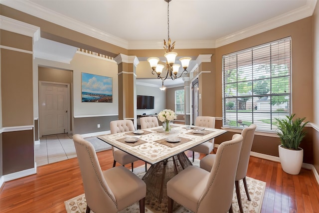 4103 Oak Blossom Ct, Houston, TX 77059 - dining space with crown molding, decorative columns, baseboards, light wood-type flooring, and a notable chandelier