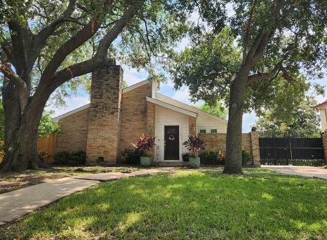 11303 Olympia Dr, Houston, TX 77077 - mid-century home with fence, a chimney, brick siding, and a front yard