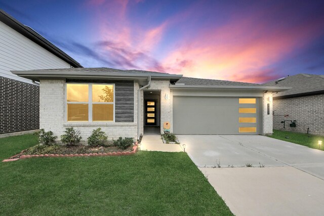 view of front of home featuring concrete driveway, brick siding, an attached garage, and a front lawn