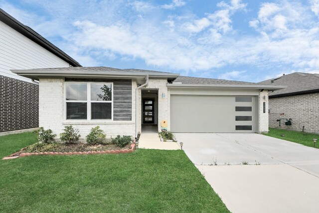 view of front facade with an attached garage, a front lawn, driveway, and brick siding