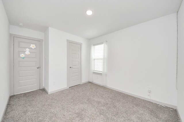 unfurnished bedroom with baseboards and light colored carpet