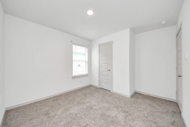 unfurnished bedroom with baseboards and light colored carpet