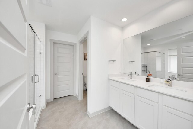 full bath with double vanity, recessed lighting, a shower stall, and a sink
