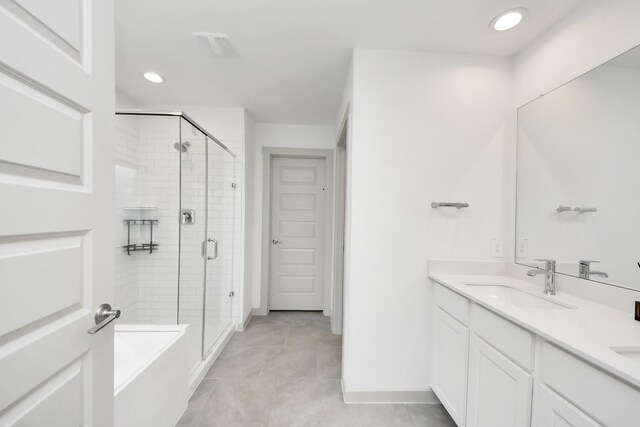 bathroom featuring double vanity, a sink, tile patterned flooring, and a stall shower