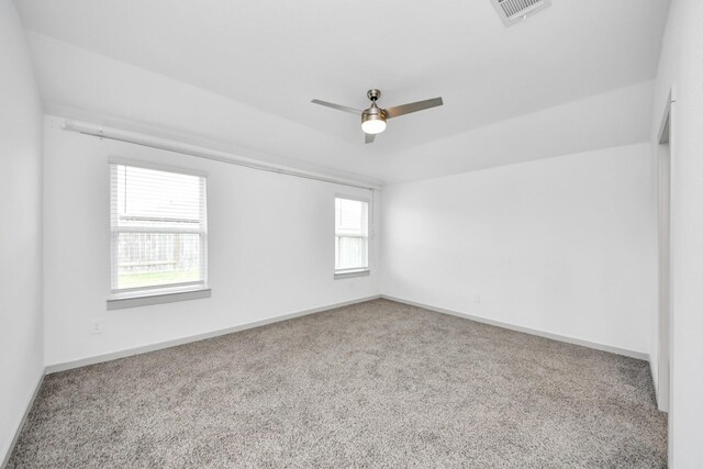 spare room with a ceiling fan, baseboards, visible vents, and carpet