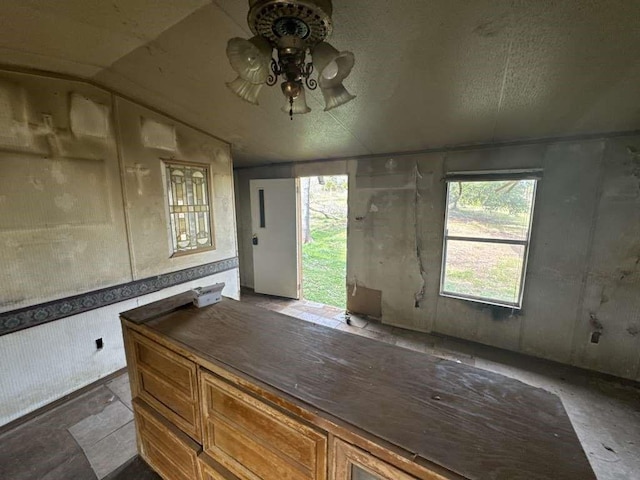 unfurnished office featuring vaulted ceiling and a ceiling fan