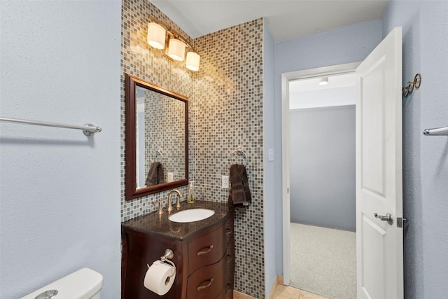 bathroom featuring vanity, tile patterned floors, toilet, and tile walls