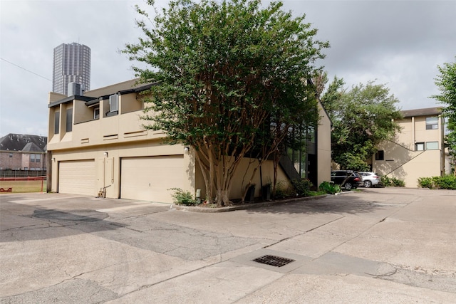 view of front of house with stucco siding, a balcony, and a garage