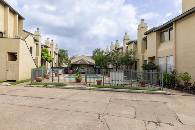 view of home's community featuring fence, a pool, and a residential view