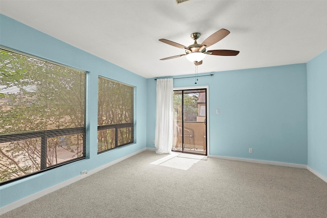 unfurnished room with baseboards, a ceiling fan, and light colored carpet