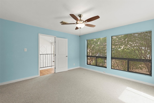 unfurnished room with a ceiling fan, baseboards, visible vents, and light carpet