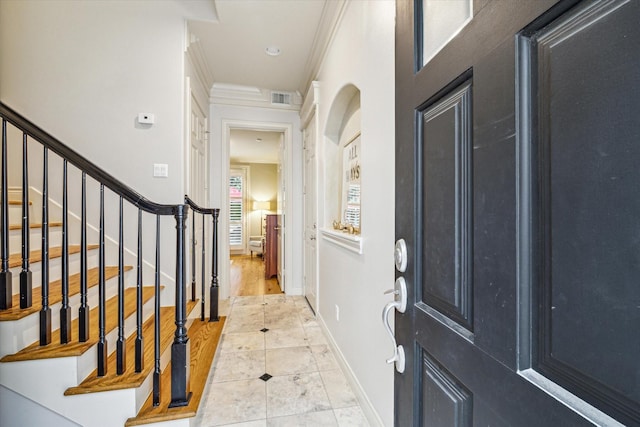 entrance foyer with visible vents, crown molding, baseboards, tile patterned floors, and stairs