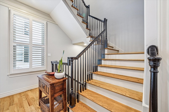 stairway with baseboards, lofted ceiling, and wood finished floors