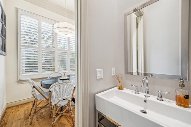 bathroom with a sink, baseboards, and wood finished floors