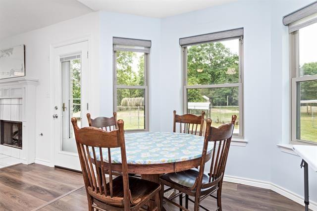 dining area with baseboards, a tiled fireplace, and dark wood-type flooring