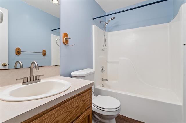 bathroom featuring shower / bath combination, vanity, and toilet