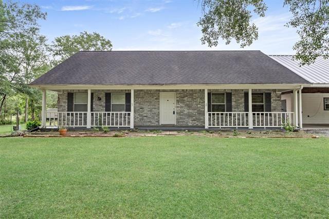 ranch-style home with a porch, a carport, and a front lawn