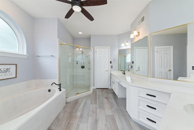 13414 Autumn Valley Dr, Cypress, TX 77429 - bathroom with a ceiling fan, a shower stall, double vanity, a garden tub, and wood finished floors