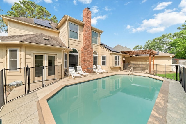 13414 Autumn Valley Dr, Cypress, TX 77429 - back of property with solar panels, a pergola, a chimney, a patio area, and a fenced backyard