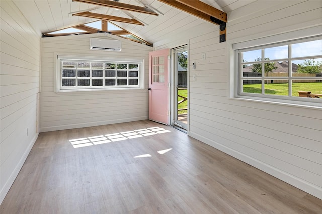 unfurnished sunroom with beamed ceiling and an AC wall unit