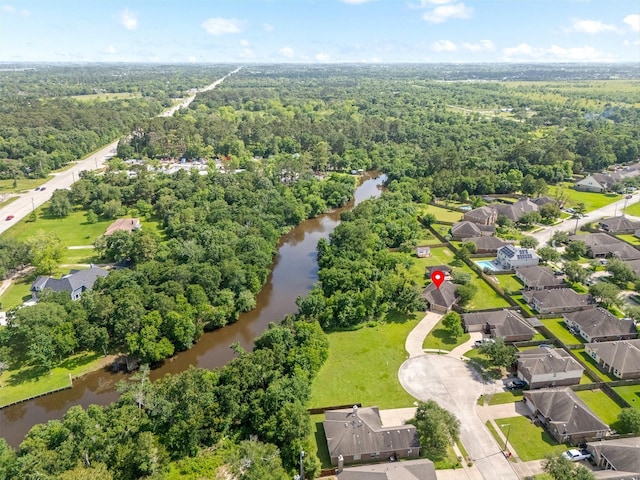 drone / aerial view with a residential view, a water view, and a wooded view