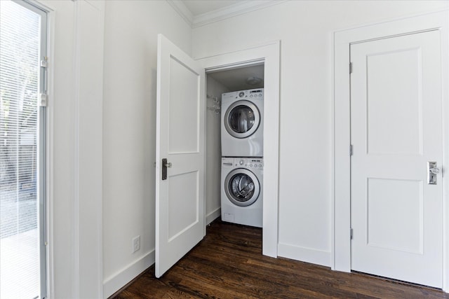 laundry area with laundry area, ornamental molding, dark wood-style flooring, baseboards, and stacked washing maching and dryer