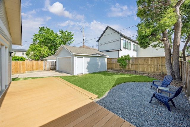 view of yard with a detached garage, a fenced backyard, a patio area, an outdoor structure, and driveway