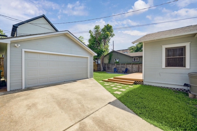 view of yard featuring a garage, fence, an outbuilding, and a deck